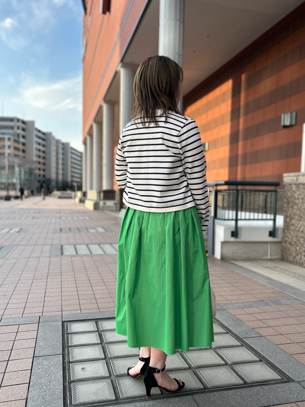 ホワイト系のカーディガン/ボレロ、グリーン系のスカート、ホワイト系のTシャツ/カットソーを着用したレディースの冬コーディネートの4枚目の写真