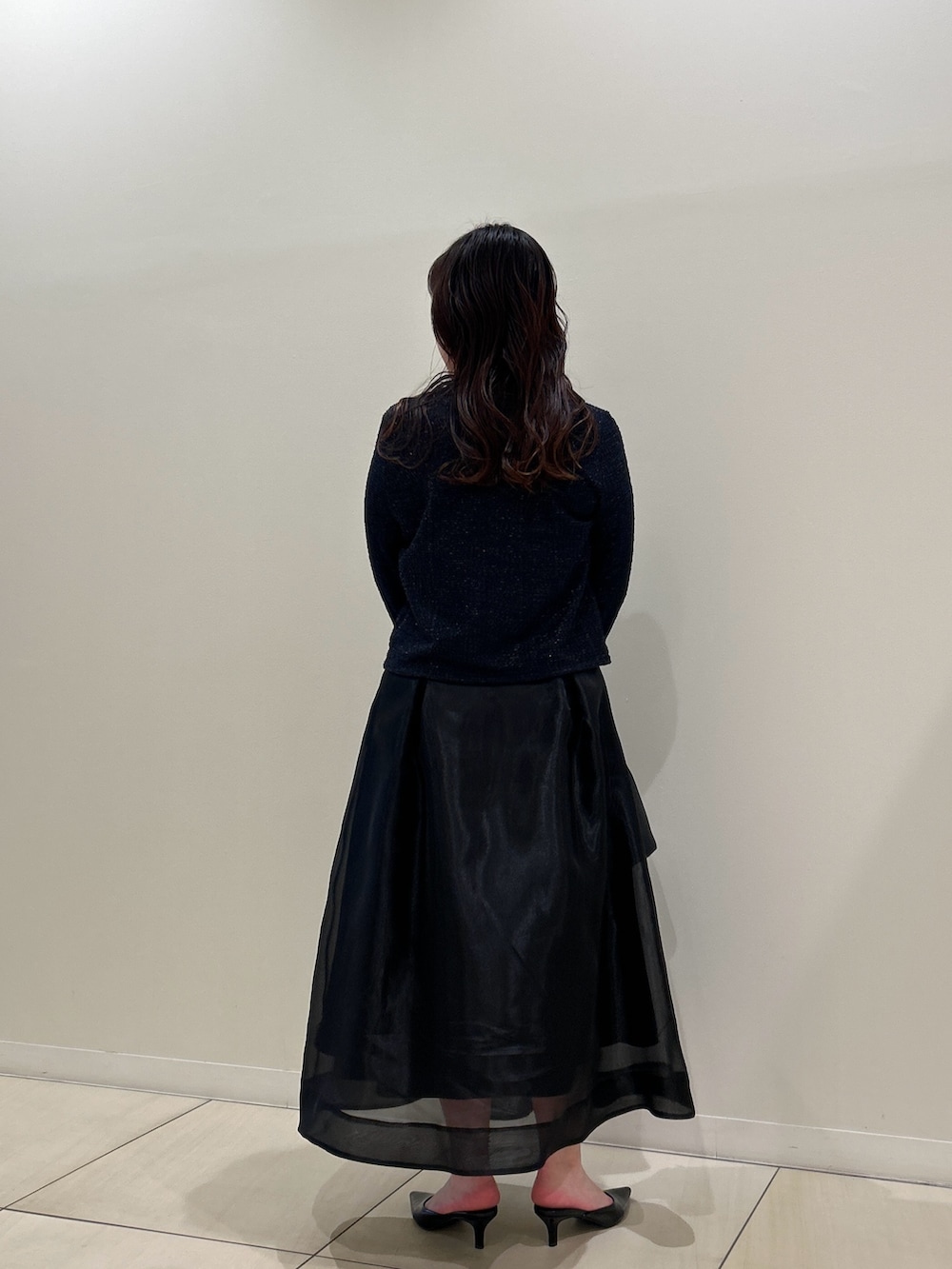 ブルー系のノーカラージャケット、ブラック系のスカート、ホワイト系のTシャツ/カットソーを着用したレディースの春コーディネートの3枚目の写真