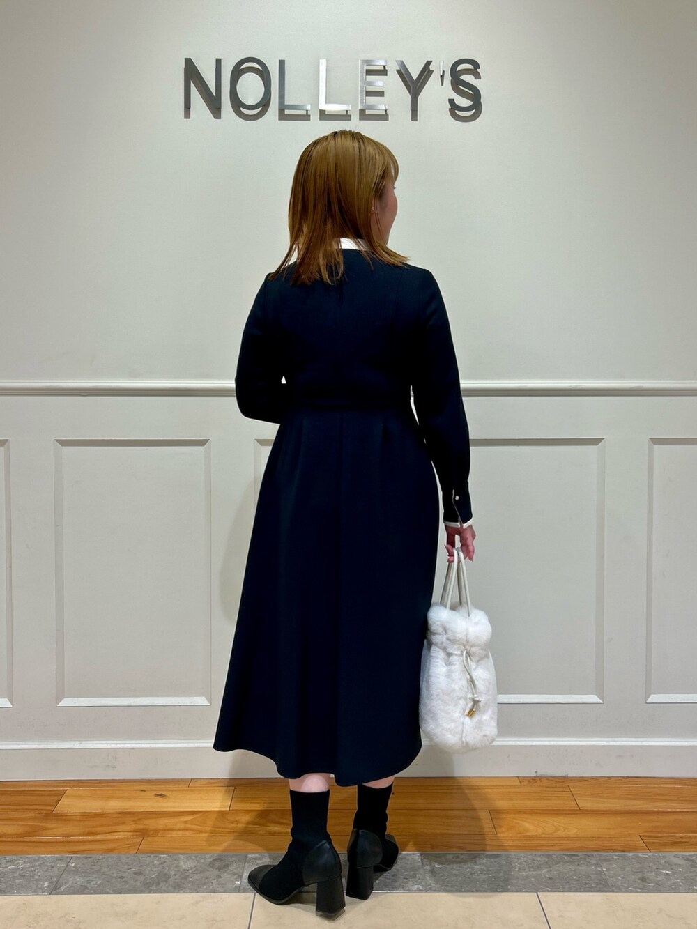 ブルー系のワンピース、ホワイト系のショルダーバッグ、ホワイト系のイヤリングを着用したレディースの冬コーディネートの6枚目の写真