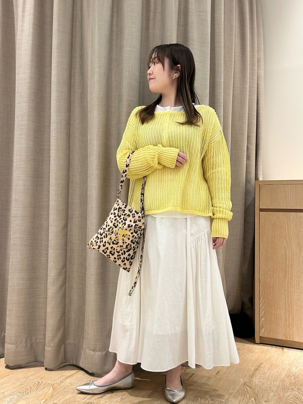 イエロー系のニット/セーター、ホワイト系のTシャツ/カットソー、ホワイト系のスカートを着用したレディースの春コーディネートの9枚目の写真