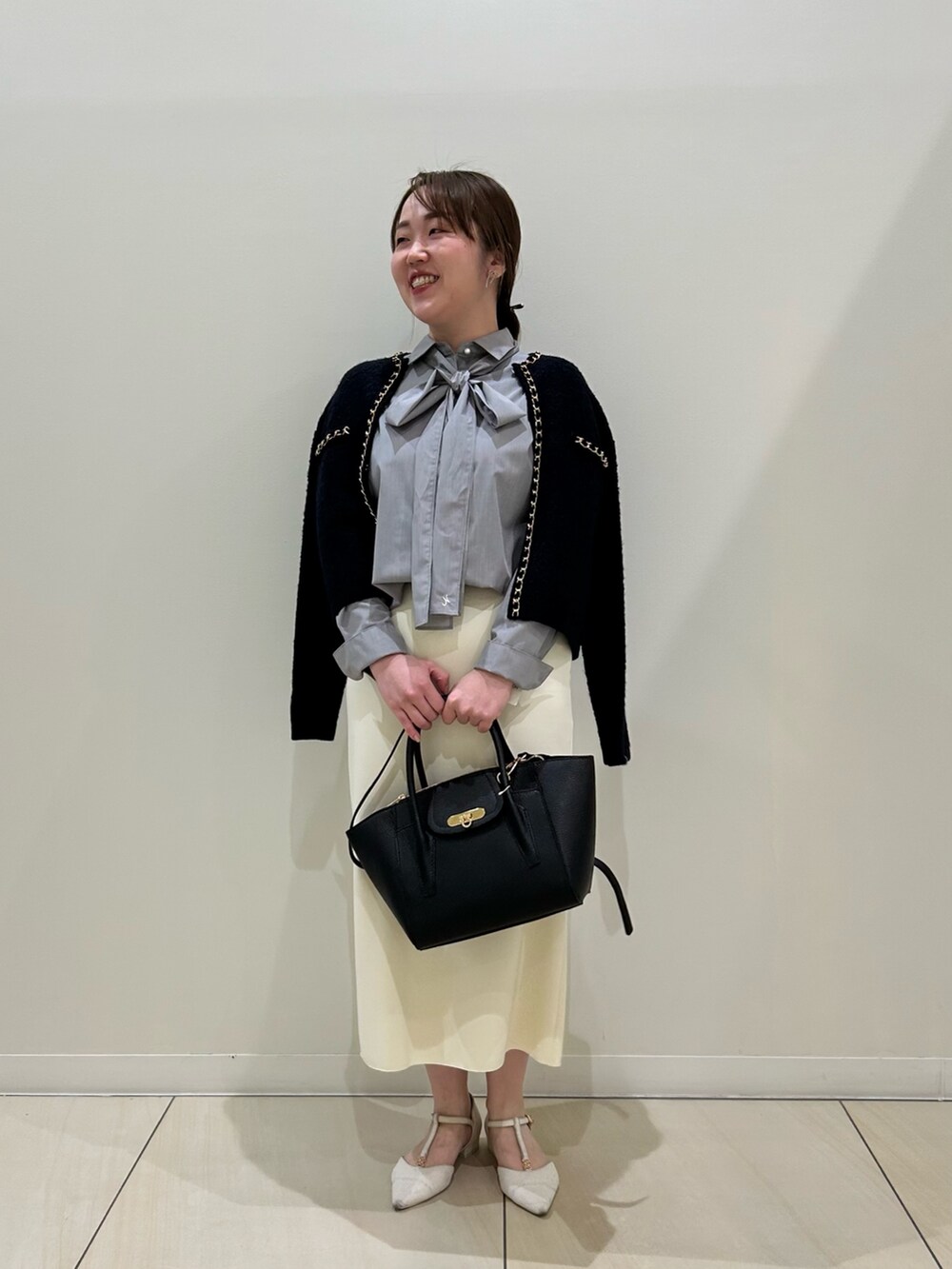 ブルー系のカーディガン/ボレロ、グレー系のシャツ/ブラウス、ホワイト系のスカートを着用したレディースの秋コーディネートの6枚目の写真