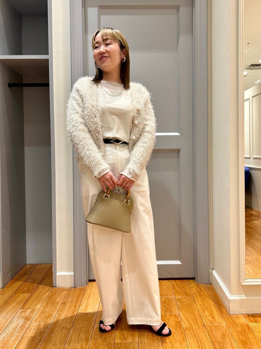 ホワイト系のカーディガン/ボレロ、ベージュ系のTシャツ/カットソー、ホワイト系のタンクトップを着用したレディースの春コーディネートの10枚目の写真