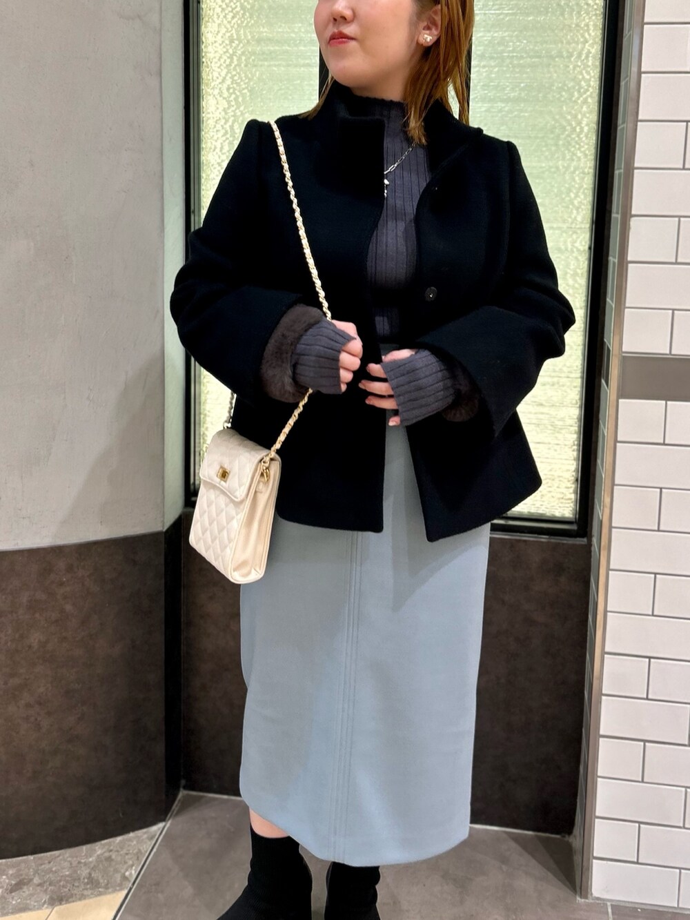 ブラック系のその他アウター、グレー系のニット/セーター、ブルー系のスカートを着用したレディースの冬コーディネートの8枚目の写真