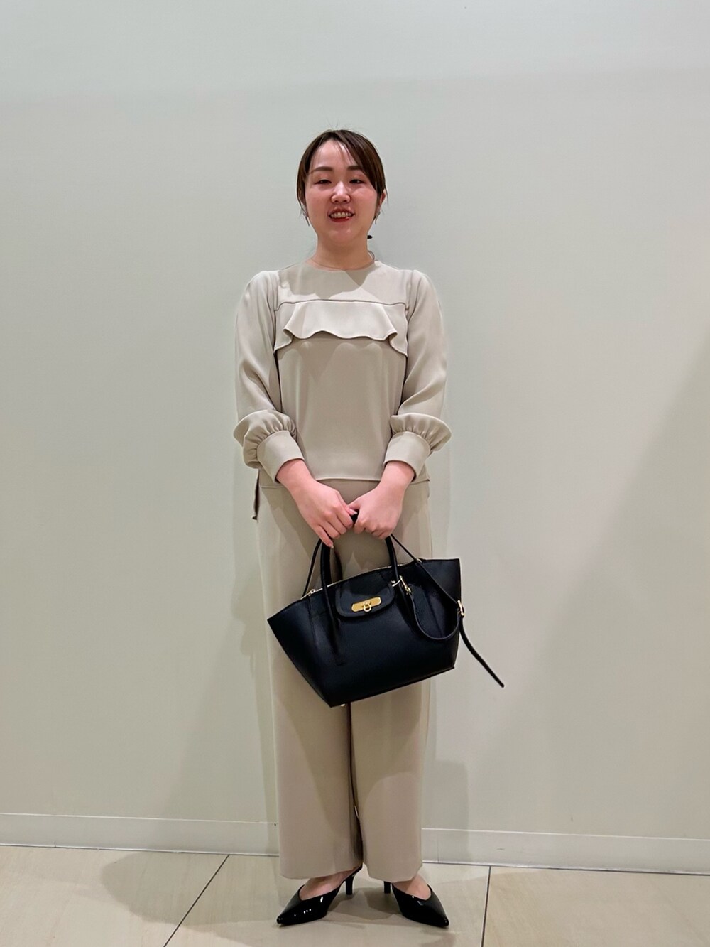 ベージュ系のシャツ/ブラウス、ベージュ系のその他パンツ、ブラック系のショルダーバッグを着用したレディースの秋コーディネートの5枚目の写真