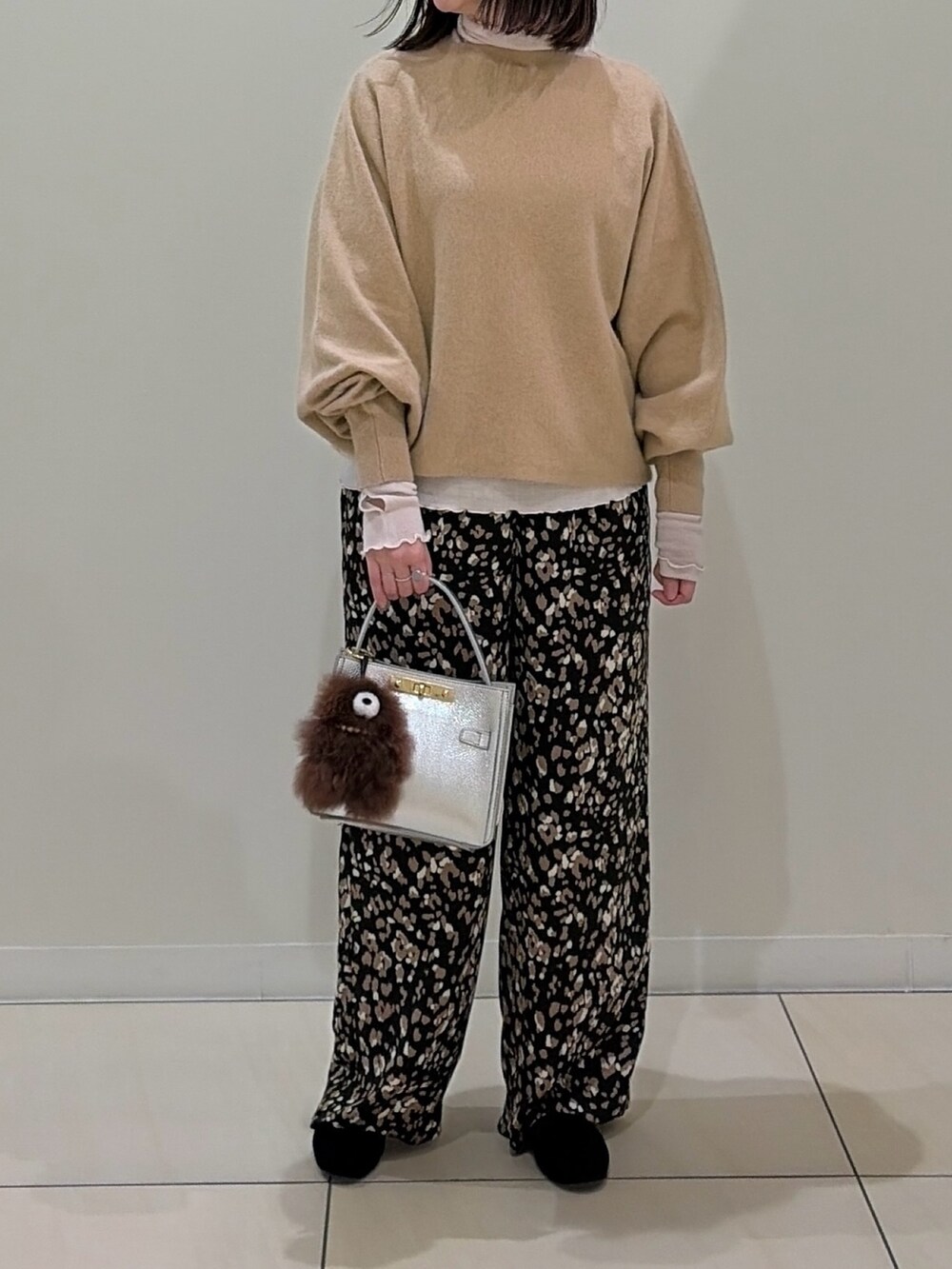 ベージュ系のニット/セーター、ホワイト系のTシャツ/カットソー、シルバー系のショルダーバッグを着用したレディースの冬コーディネートの6枚目の写真