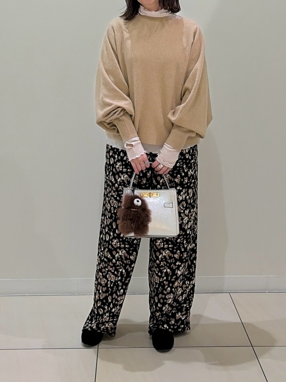 ベージュ系のニット/セーター、ホワイト系のTシャツ/カットソー、シルバー系のショルダーバッグを着用したレディースの冬コーディネートの8枚目の写真
