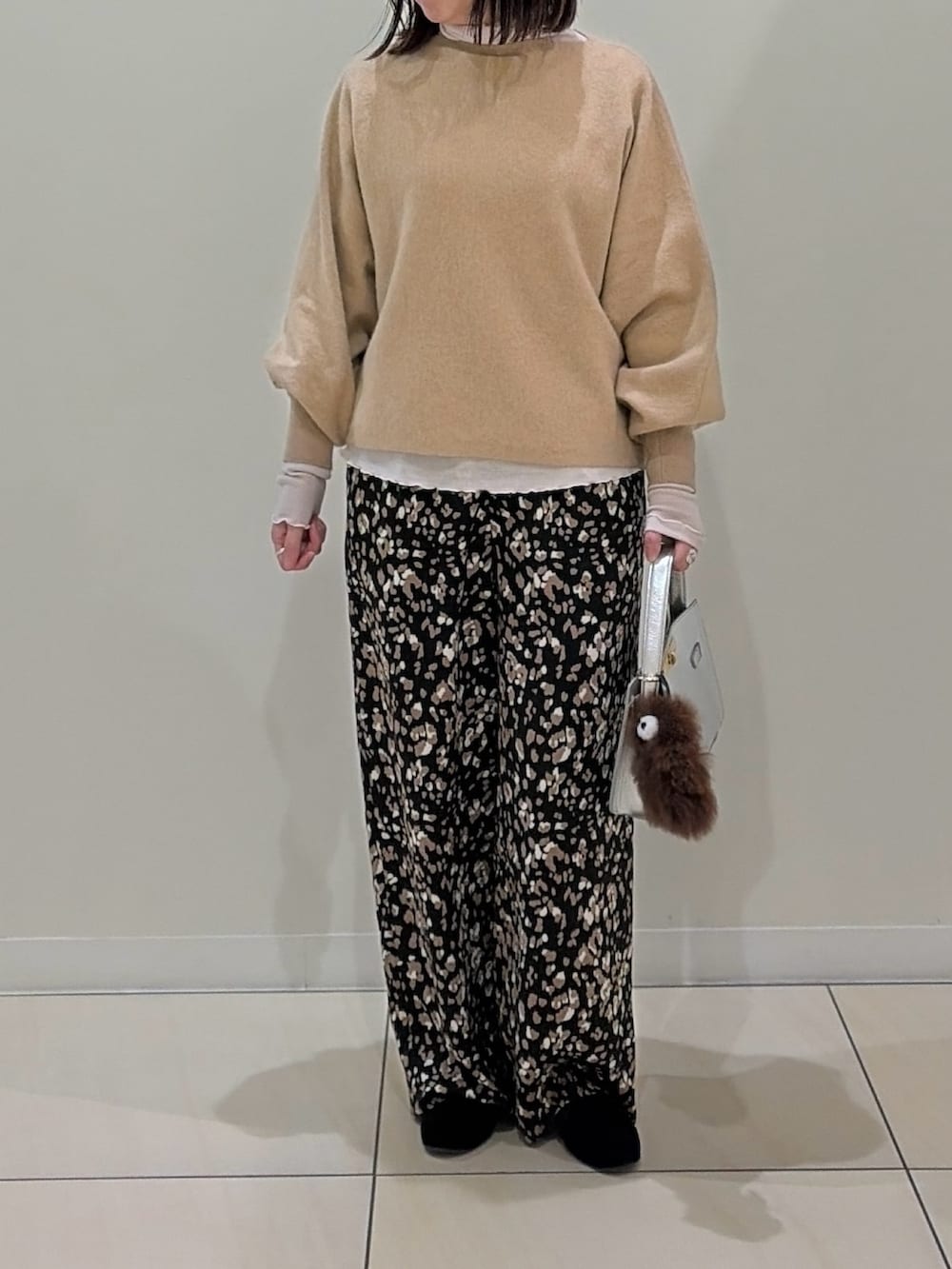 ベージュ系のニット/セーター、ホワイト系のTシャツ/カットソー、シルバー系のショルダーバッグを着用したレディースの冬コーディネートの9枚目の写真