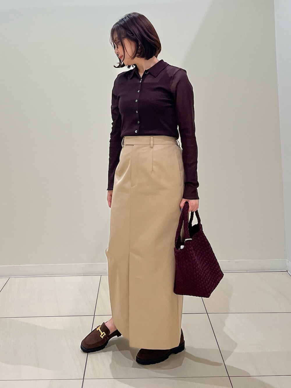 ブラウン系のカーディガン/ボレロ、ブラウン系のタンクトップ、レッド系のショルダーバッグを着用したレディースの秋コーディネートの7枚目の写真