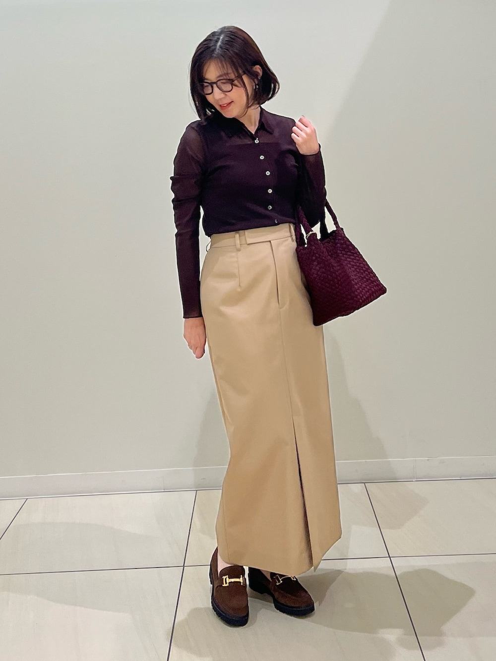 ブラウン系のカーディガン/ボレロ、ブラウン系のタンクトップ、レッド系のショルダーバッグを着用したレディースの秋コーディネートの3枚目の写真