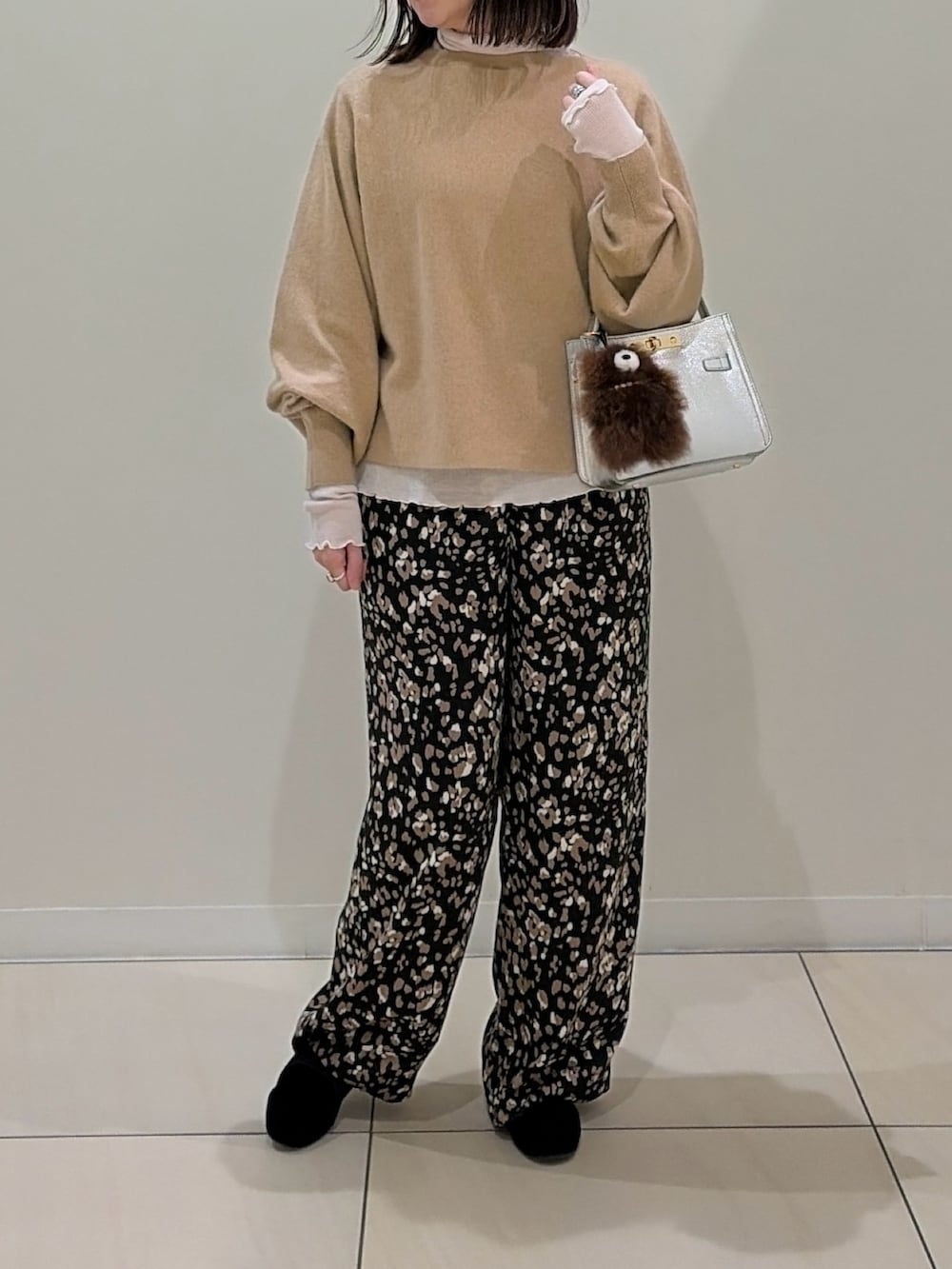 ベージュ系のニット/セーター、ホワイト系のTシャツ/カットソー、シルバー系のショルダーバッグを着用したレディースの冬コーディネートの2枚目の写真