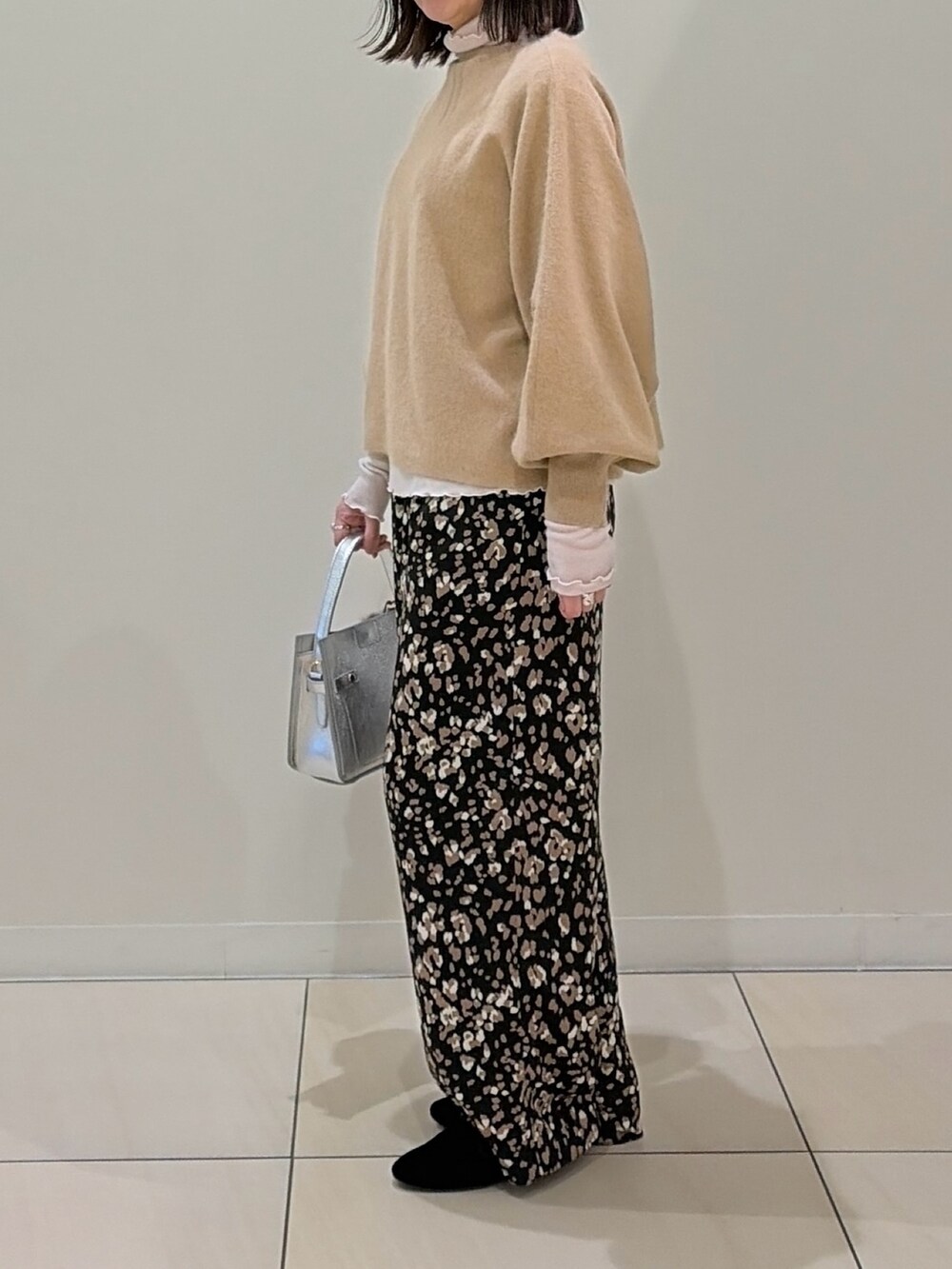 ベージュ系のニット/セーター、ホワイト系のTシャツ/カットソー、シルバー系のショルダーバッグを着用したレディースの冬コーディネートの4枚目の写真