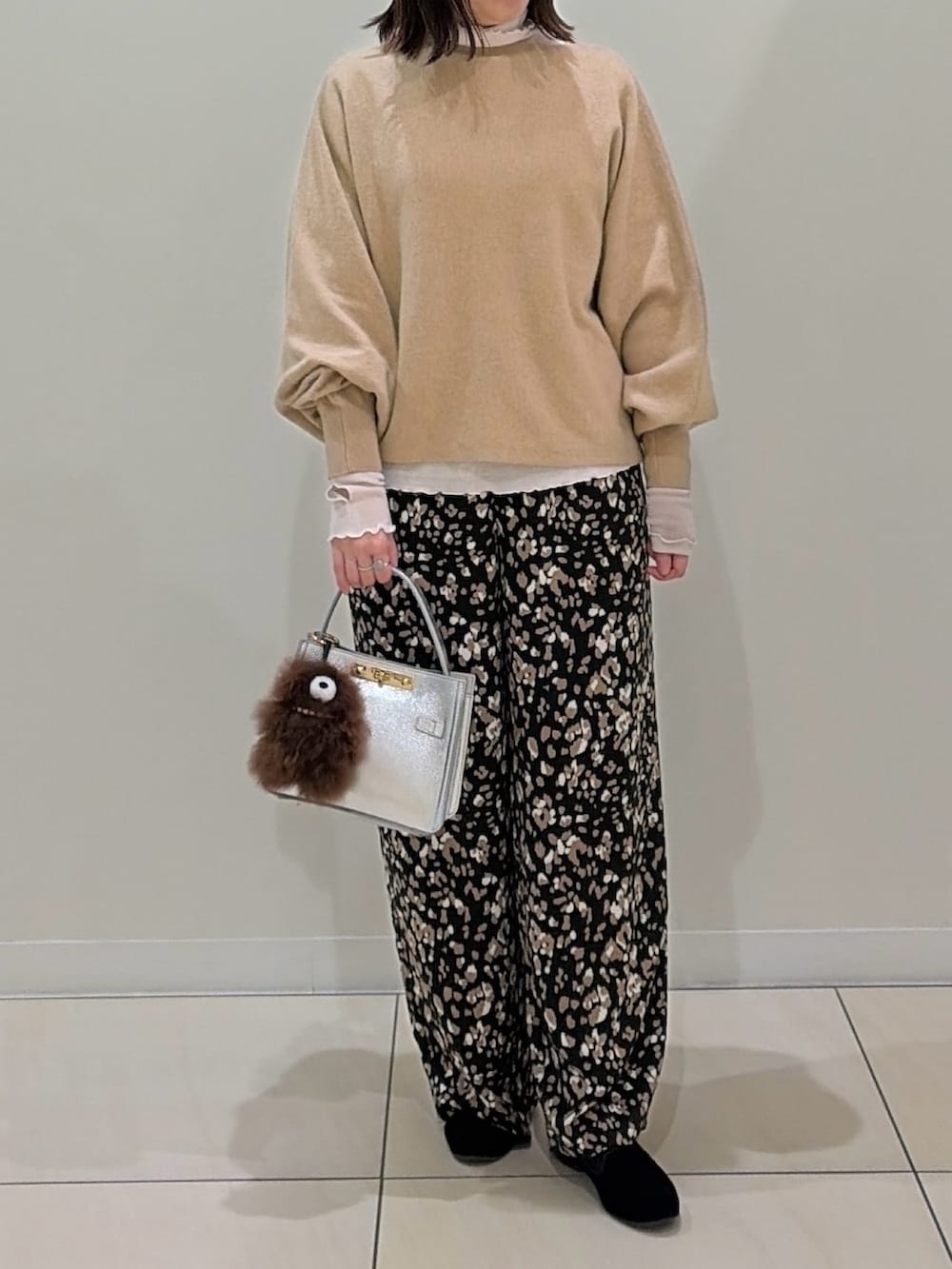ベージュ系のニット/セーター、ホワイト系のTシャツ/カットソー、シルバー系のショルダーバッグを着用したレディースの冬コーディネートの7枚目の写真