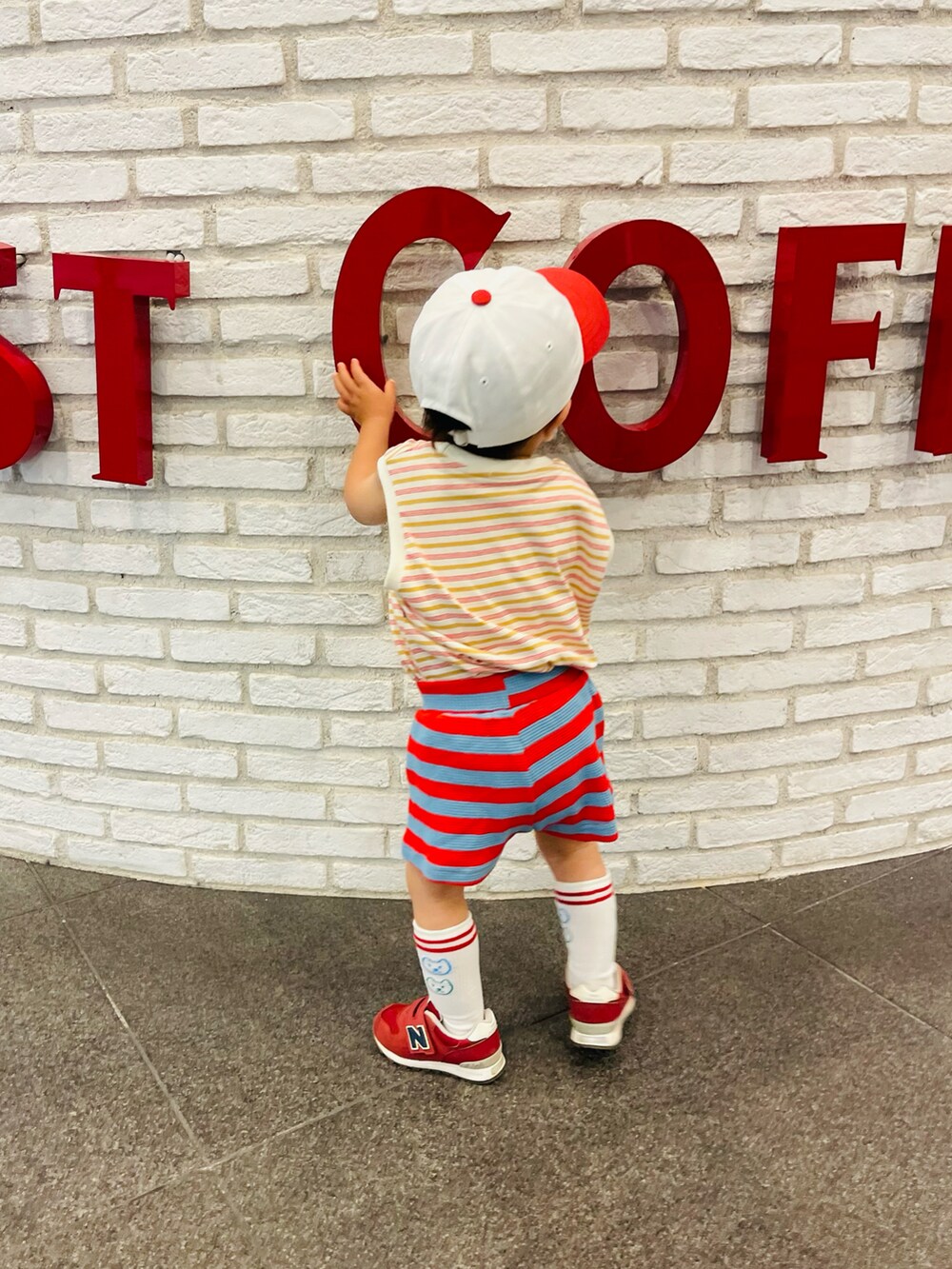 レッド系のスニーカー、レッド系のトップス、レッド系のパンツを着用したキッズの春コーディネートの5枚目の写真