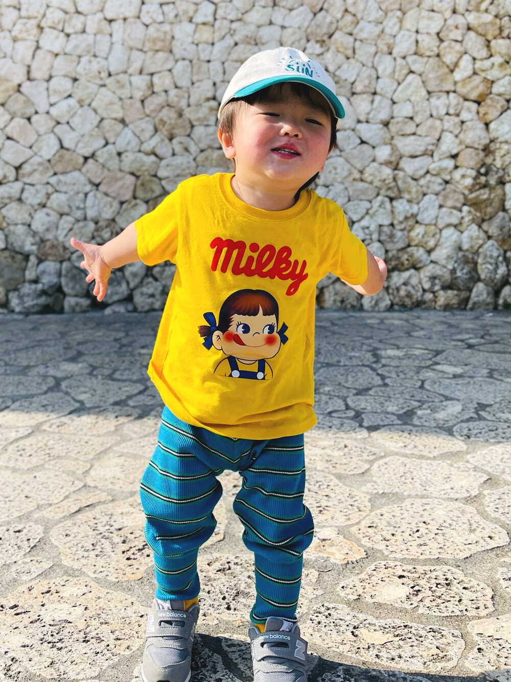 ブルー系のパンツ、イエロー系のTシャツ/カットソー、グレー系のスニーカーを着用したキッズの冬コーディネートの2枚目の写真