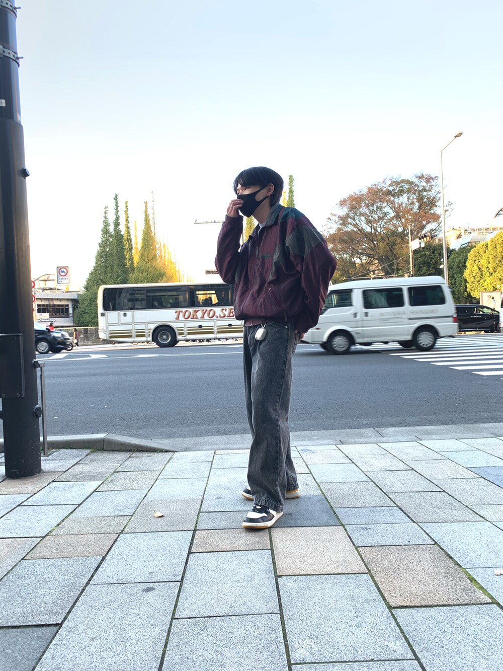 ブラック系のデニムパンツ、その他のスニーカー、レッド系のナイロンジャケットを着用したメンズの秋コーディネートの3枚目の写真