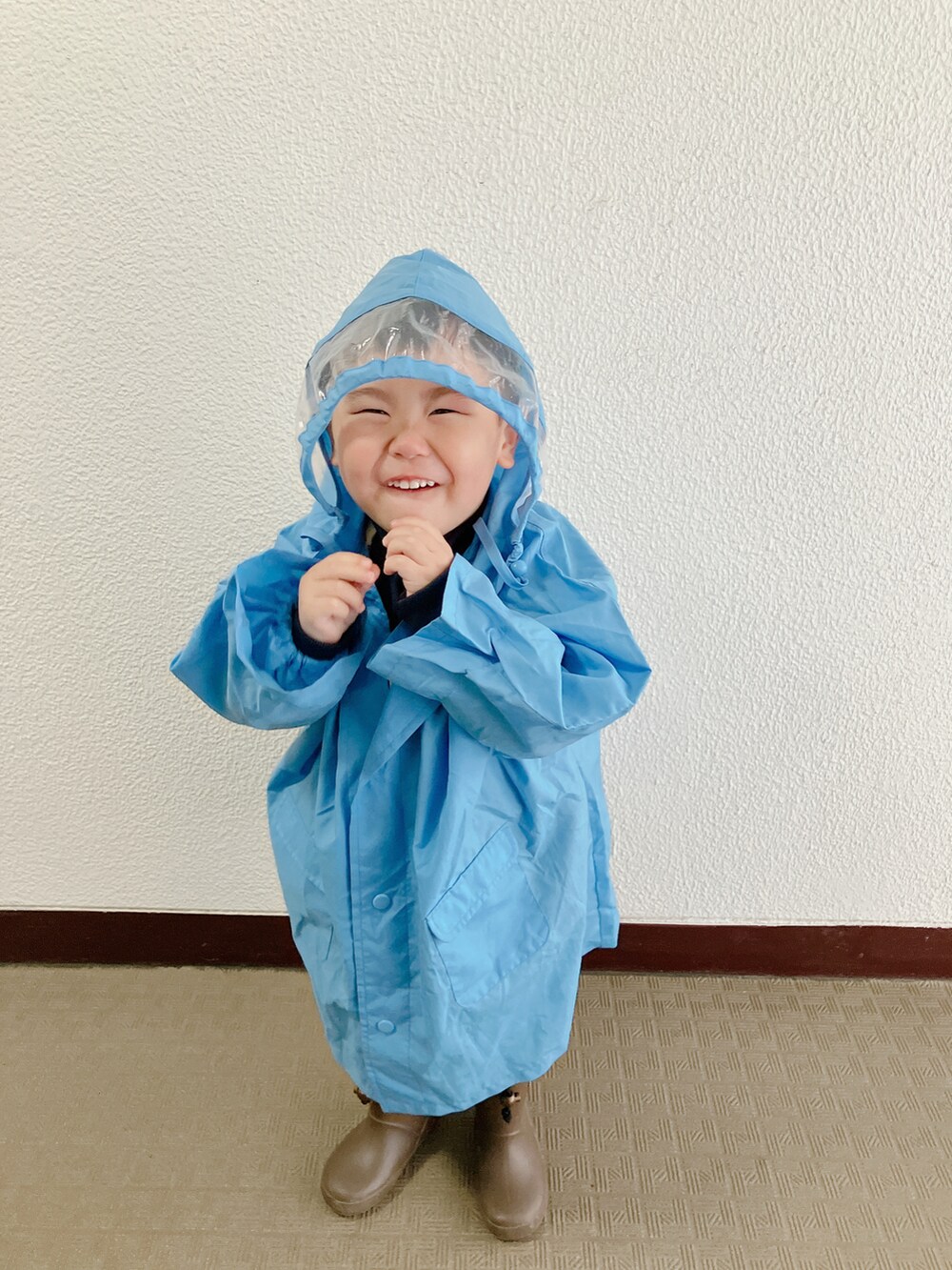 ブルー系のポンチョを着用したキッズの春コーディネートの4枚目の写真