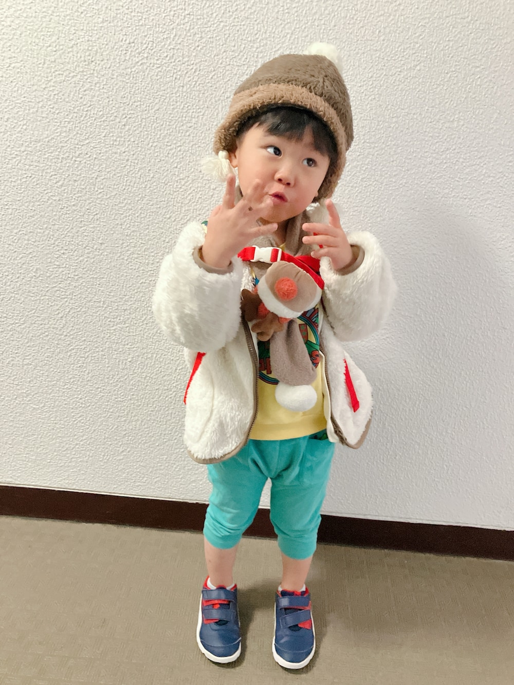 ホワイト系のムートンコートを着用したキッズの冬コーディネートの2枚目の写真