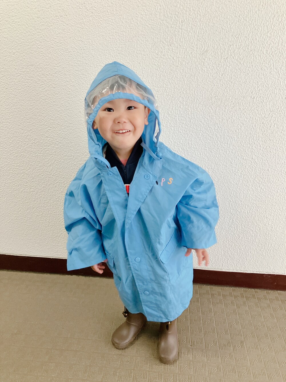 ブルー系のポンチョを着用したキッズの春コーディネートの5枚目の写真