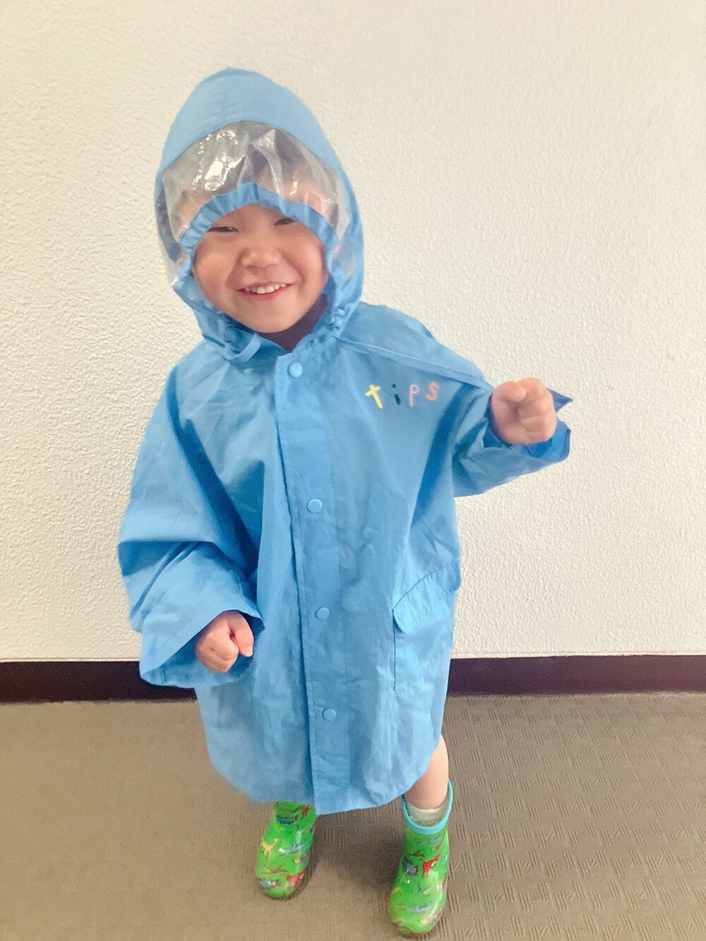 グリーン系のレインシューズを着用したキッズの春コーディネートの2枚目の写真