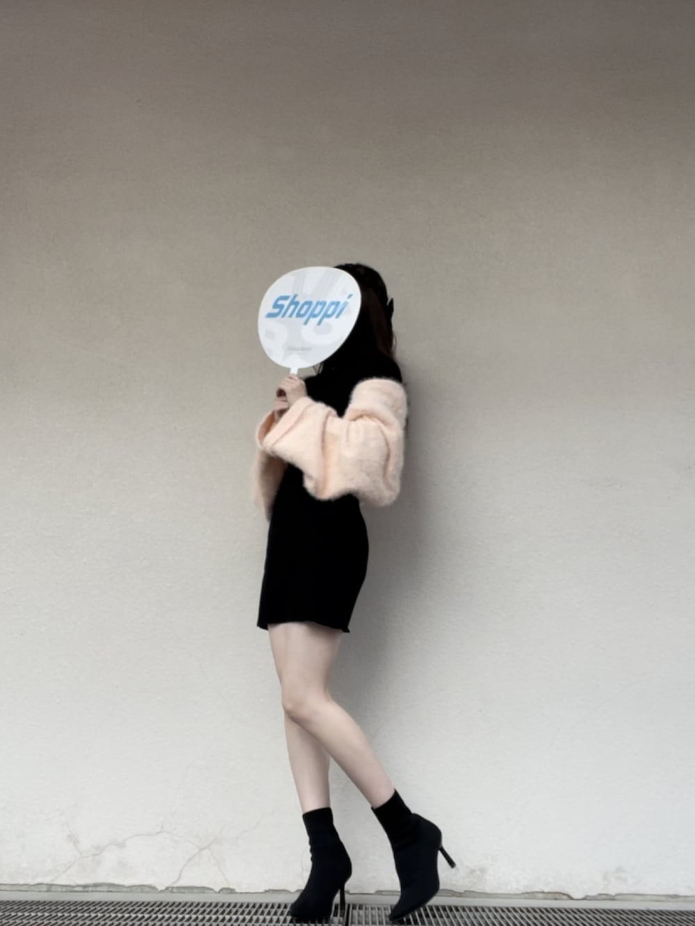 ピンク系のその他アウター、ブラック系のワンピース、ブラック系のブーツを着用したレディースの冬コーディネートの2枚目の写真