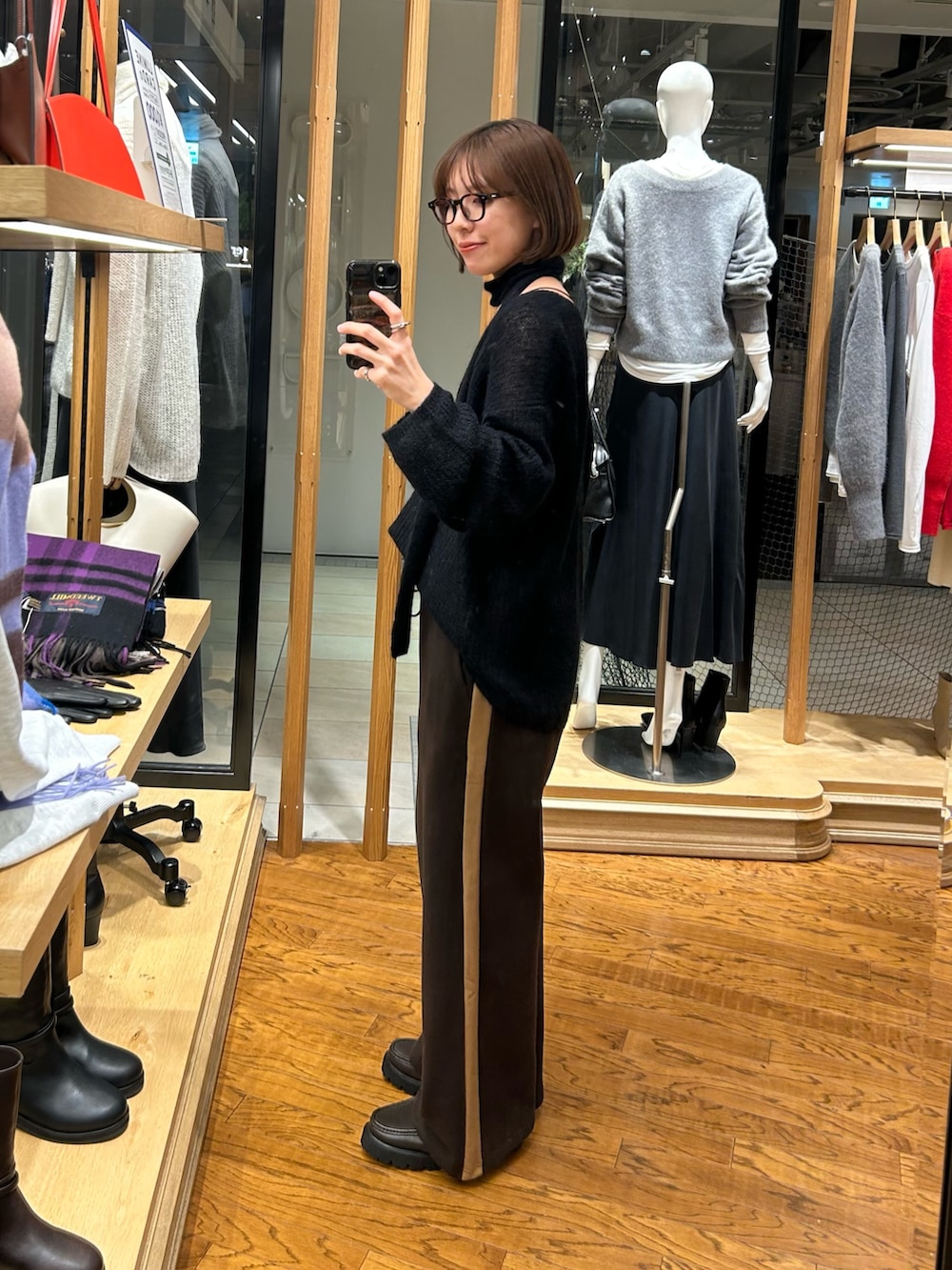 ブラウン系のスウェットパンツ、ブラック系のニット/セーターを着用したレディースの秋コーディネートの2枚目の写真