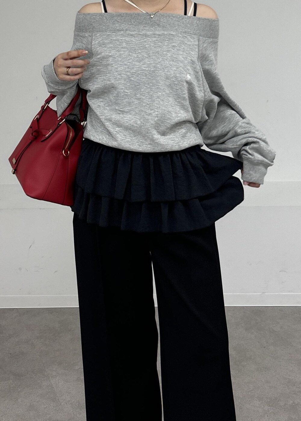 レッド系のボストンバッグ、ブラック系のキャミソール、グレー系のスウェットを着用したレディースの秋コーディネートの4枚目の写真