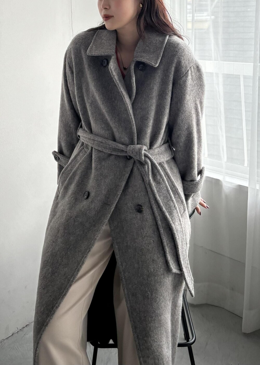 ホワイト系のショルダーバッグ、グレー系のステンカラーコート、ベージュ系のその他パンツを着用したレディースの秋コーディネートの7枚目の写真