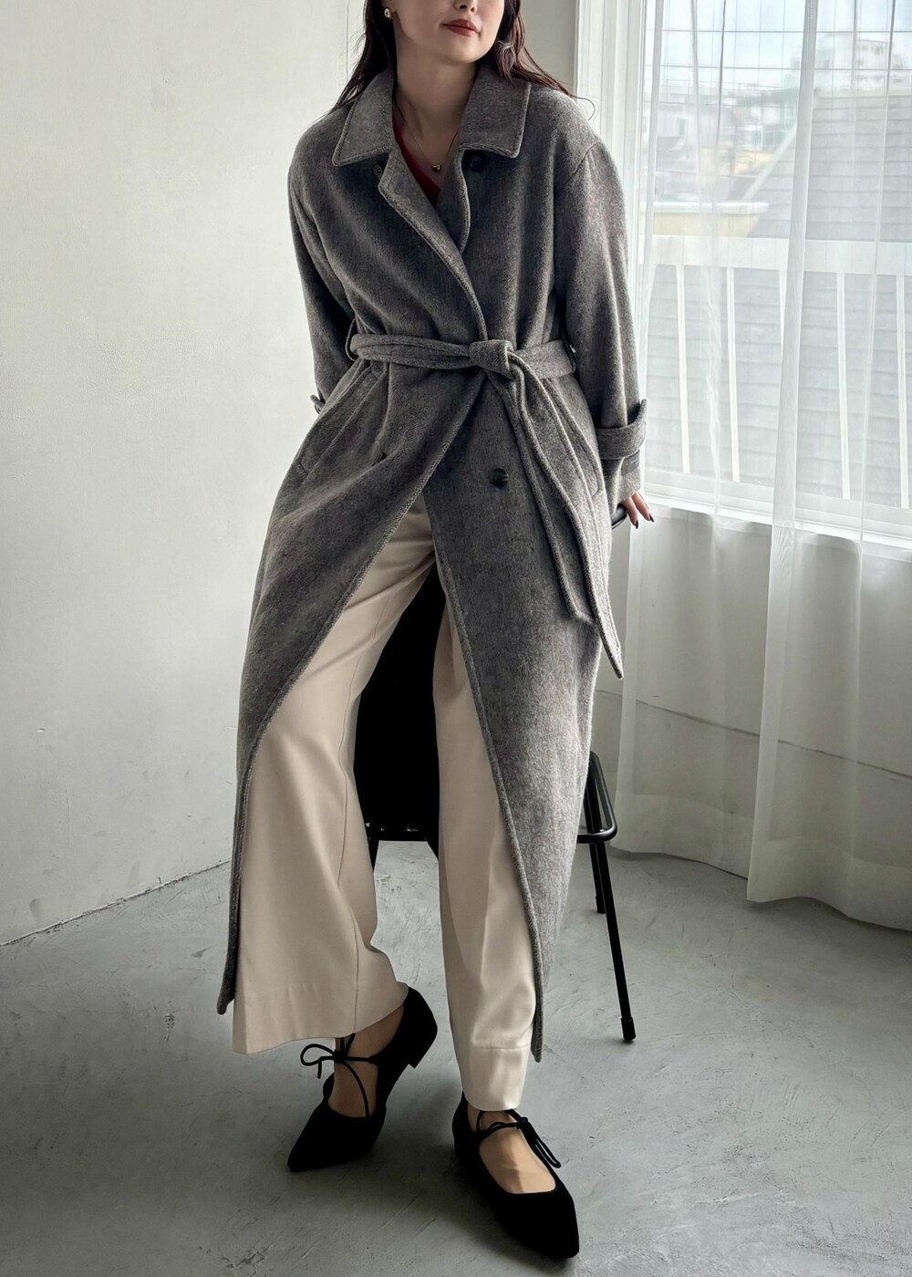 ホワイト系のショルダーバッグ、グレー系のステンカラーコート、ベージュ系のその他パンツを着用したレディースの秋コーディネートの6枚目の写真