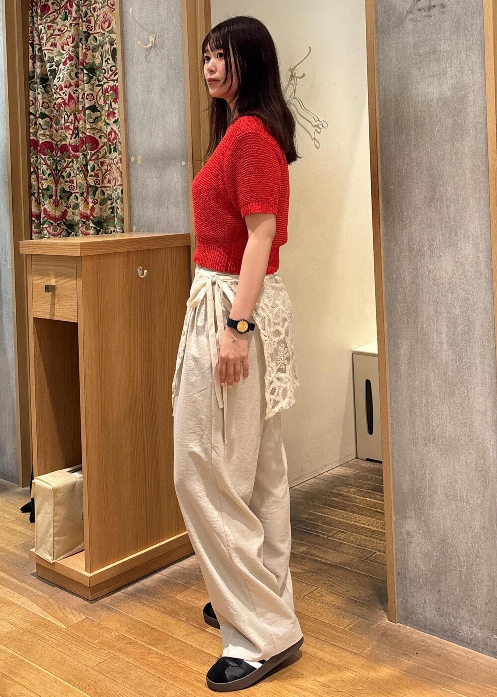 ホワイト系のスラックス、レッド系のニット/セーター、ホワイト系のスカートを着用したレディースの夏コーディネートの3枚目の写真