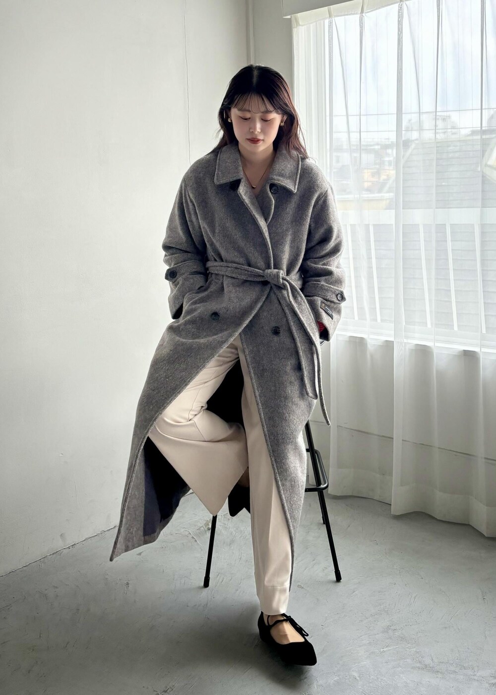 ホワイト系のショルダーバッグ、グレー系のステンカラーコート、ベージュ系のその他パンツを着用したレディースの秋コーディネートの5枚目の写真
