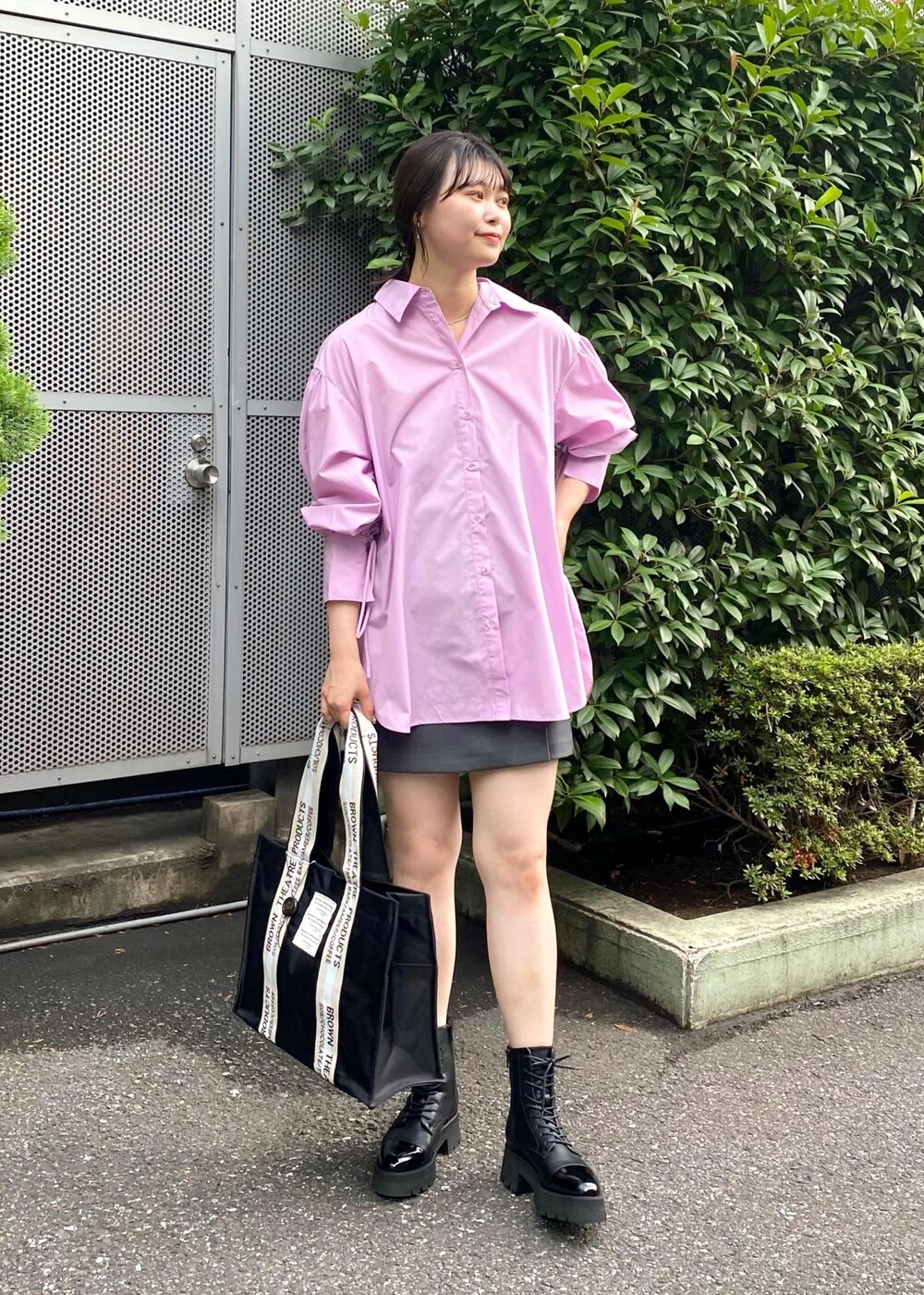 ブラック系のトートバッグ、ピンク系のシャツ/ブラウス、グレー系のスカートを着用したレディースの夏コーディネートの2枚目の写真