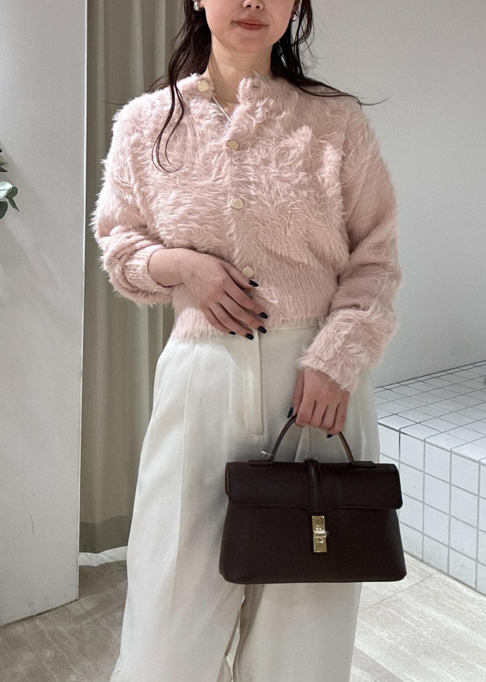 ブラウン系のショルダーバッグ、ブラック系のブーツ、ピンク系のカーディガン/ボレロを着用したレディースの冬コーディネートの5枚目の写真