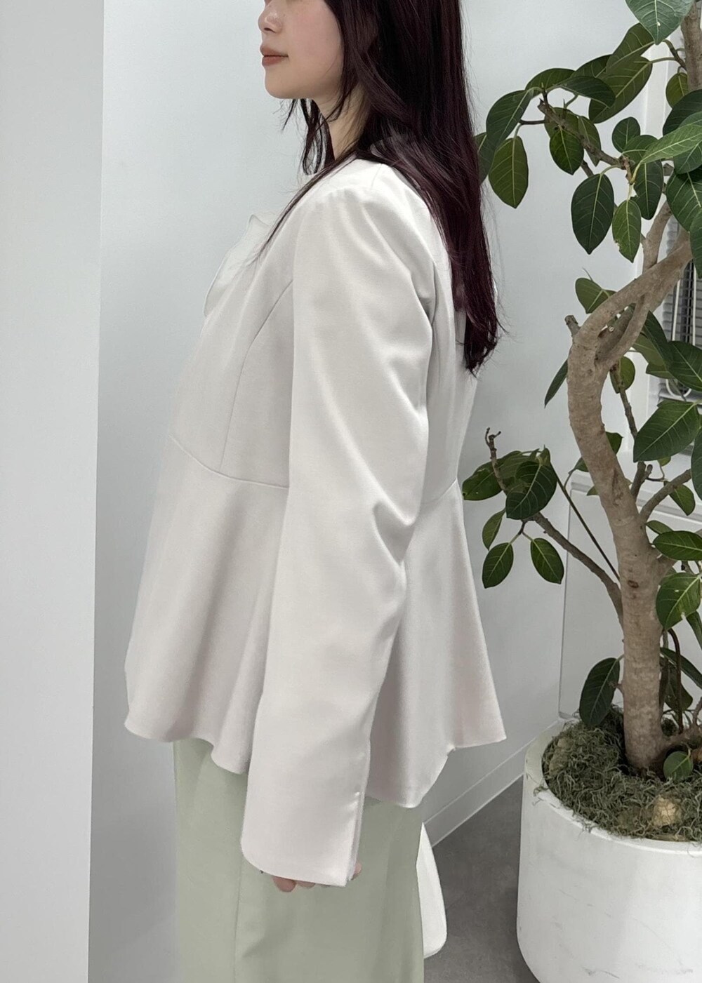 ホワイト系のショルダーバッグ、グリーン系のスラックス、ブラック系のバレエシューズを着用したレディースの冬コーディネートの8枚目の写真