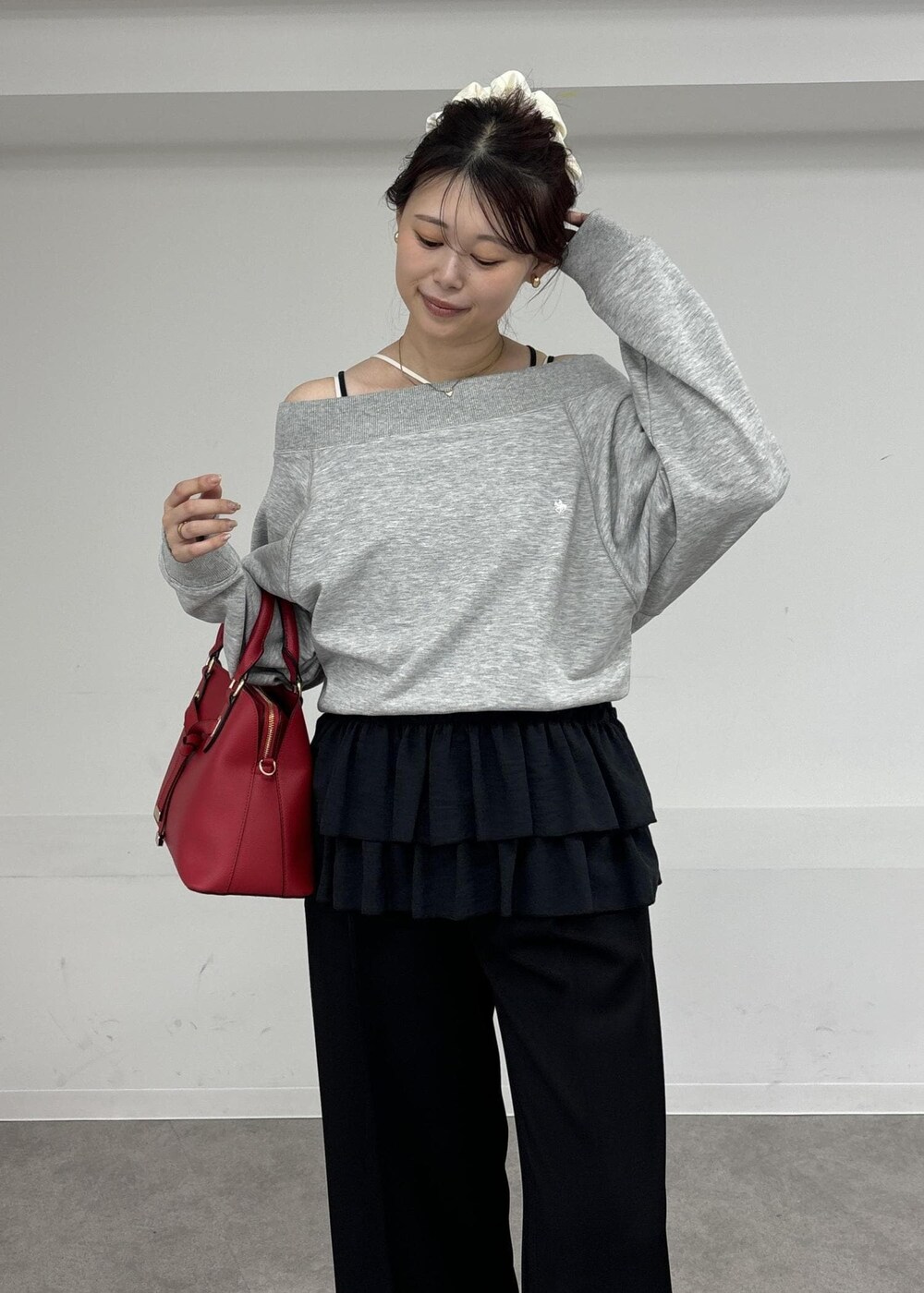 レッド系のボストンバッグ、ブラック系のキャミソール、グレー系のスウェットを着用したレディースの秋コーディネートの6枚目の写真