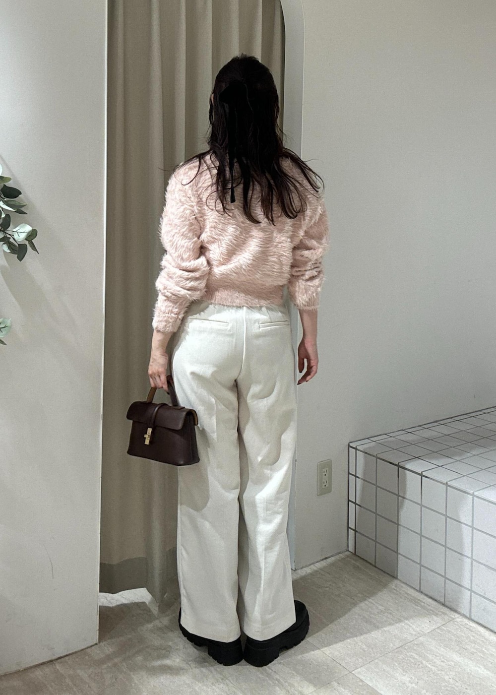 ブラウン系のショルダーバッグ、ブラック系のブーツ、ピンク系のカーディガン/ボレロを着用したレディースの冬コーディネートの4枚目の写真