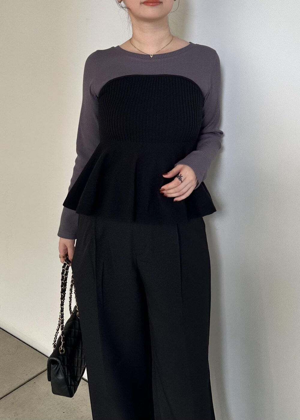 ブラック系のニット/セーター、ブラック系のスラックスを着用したレディースの秋コーディネートの5枚目の写真