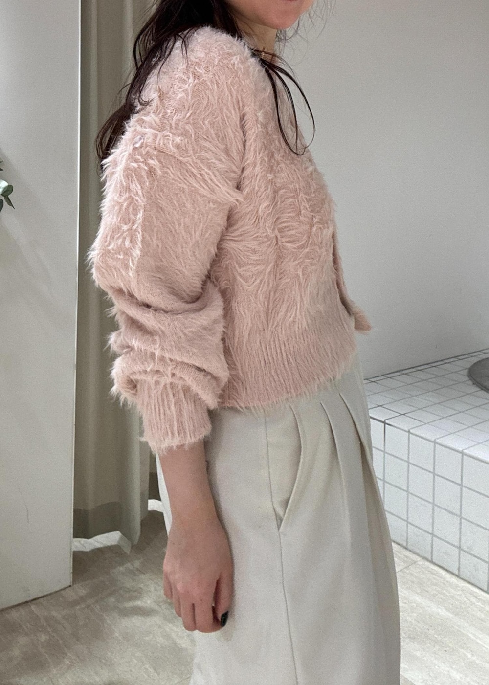 ブラウン系のショルダーバッグ、ブラック系のブーツ、ピンク系のカーディガン/ボレロを着用したレディースの冬コーディネートの7枚目の写真