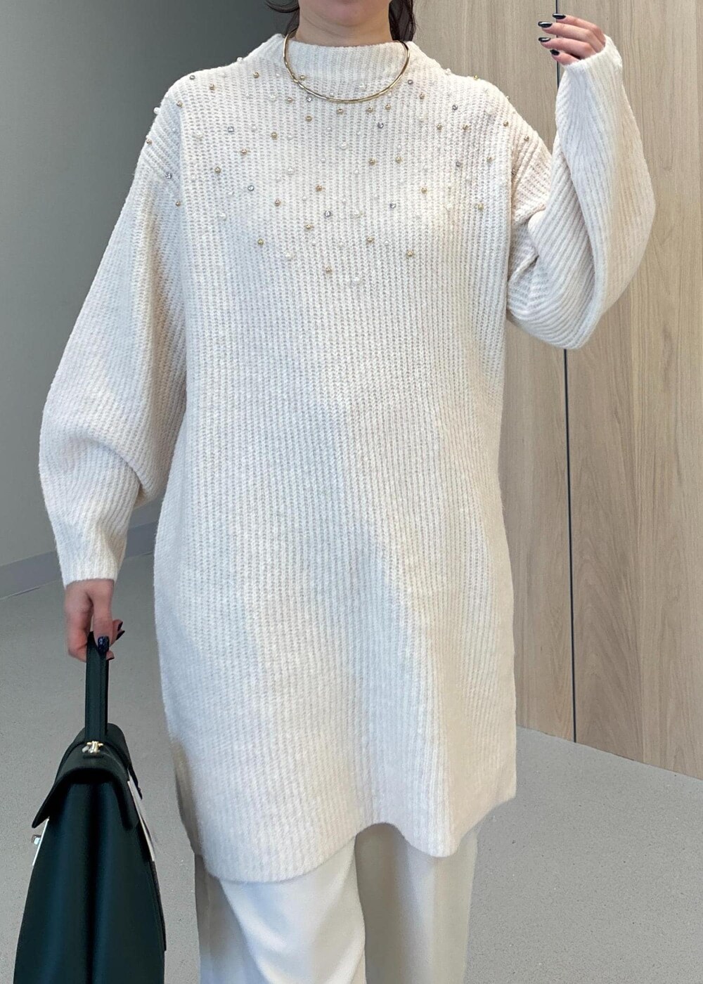 グリーン系のハンドバッグ、ベージュ系のブーツ、ホワイト系のワンピースを着用したレディースの冬コーディネートの5枚目の写真