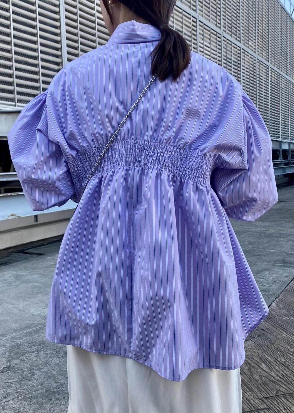 ホワイト系のブーツ、ホワイト系のスカート、パープル系のシャツ/ブラウスを着用したレディースの冬コーディネートの5枚目の写真