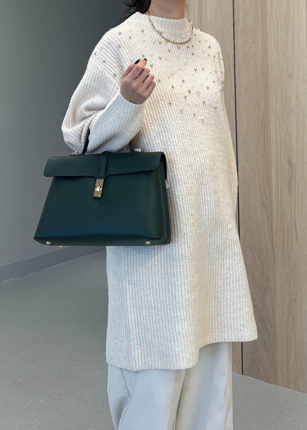 グリーン系のハンドバッグ、ベージュ系のブーツ、ホワイト系のワンピースを着用したレディースの冬コーディネートの8枚目の写真