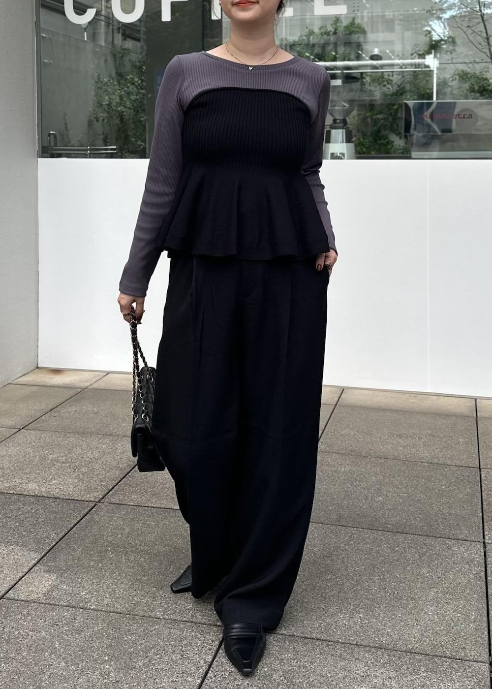 ブラック系のニット/セーター、ブラック系のスラックスを着用したレディースの秋コーディネートの2枚目の写真