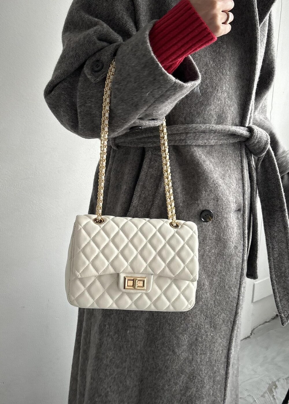 ホワイト系のショルダーバッグ、グレー系のステンカラーコート、ベージュ系のその他パンツを着用したレディースの秋コーディネートの9枚目の写真