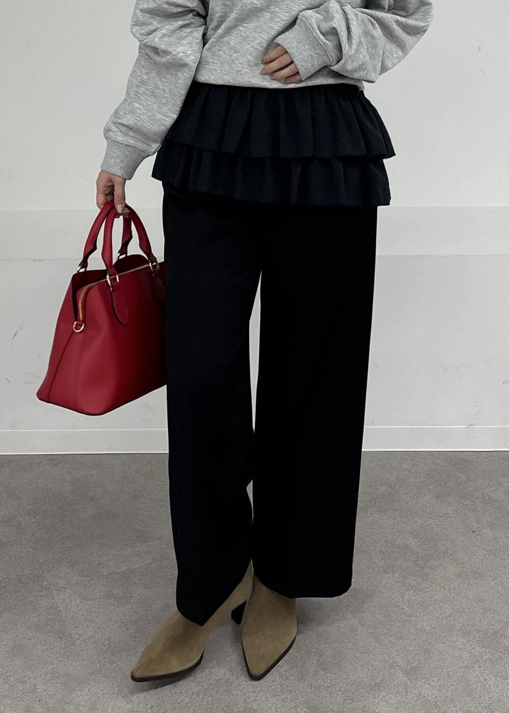 レッド系のボストンバッグ、ブラック系のキャミソール、グレー系のスウェットを着用したレディースの秋コーディネートの5枚目の写真