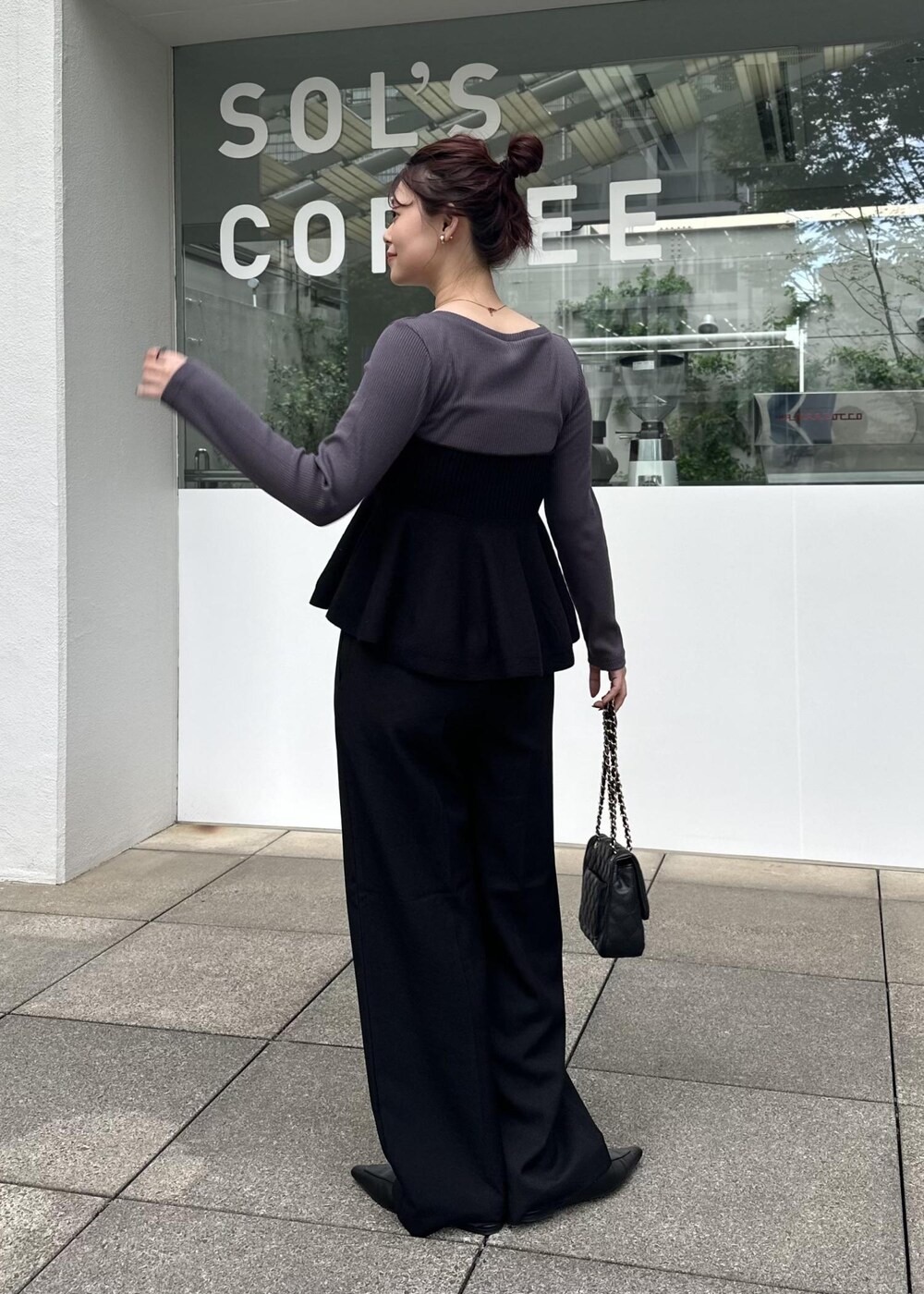 ブラック系のニット/セーター、ブラック系のスラックスを着用したレディースの秋コーディネートの4枚目の写真