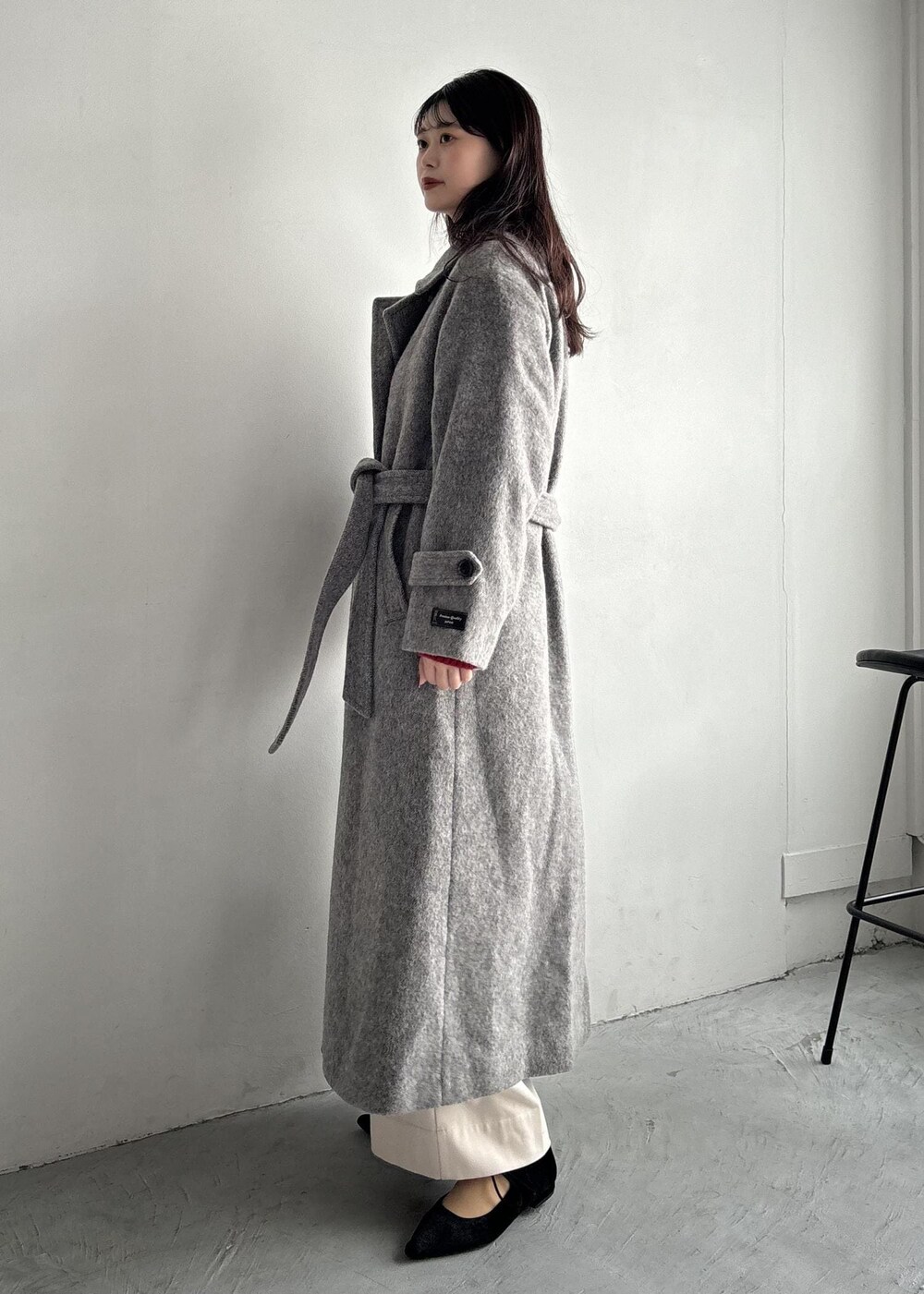 ホワイト系のショルダーバッグ、グレー系のステンカラーコート、ベージュ系のその他パンツを着用したレディースの秋コーディネートの3枚目の写真