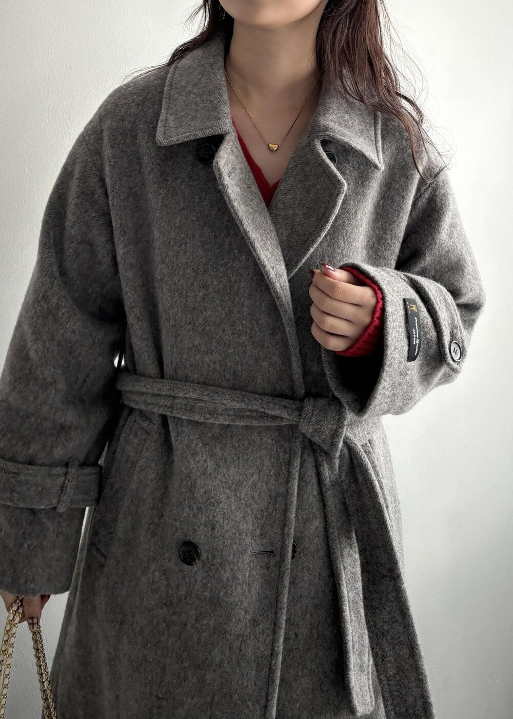 ホワイト系のショルダーバッグ、グレー系のステンカラーコート、ベージュ系のその他パンツを着用したレディースの秋コーディネートの8枚目の写真