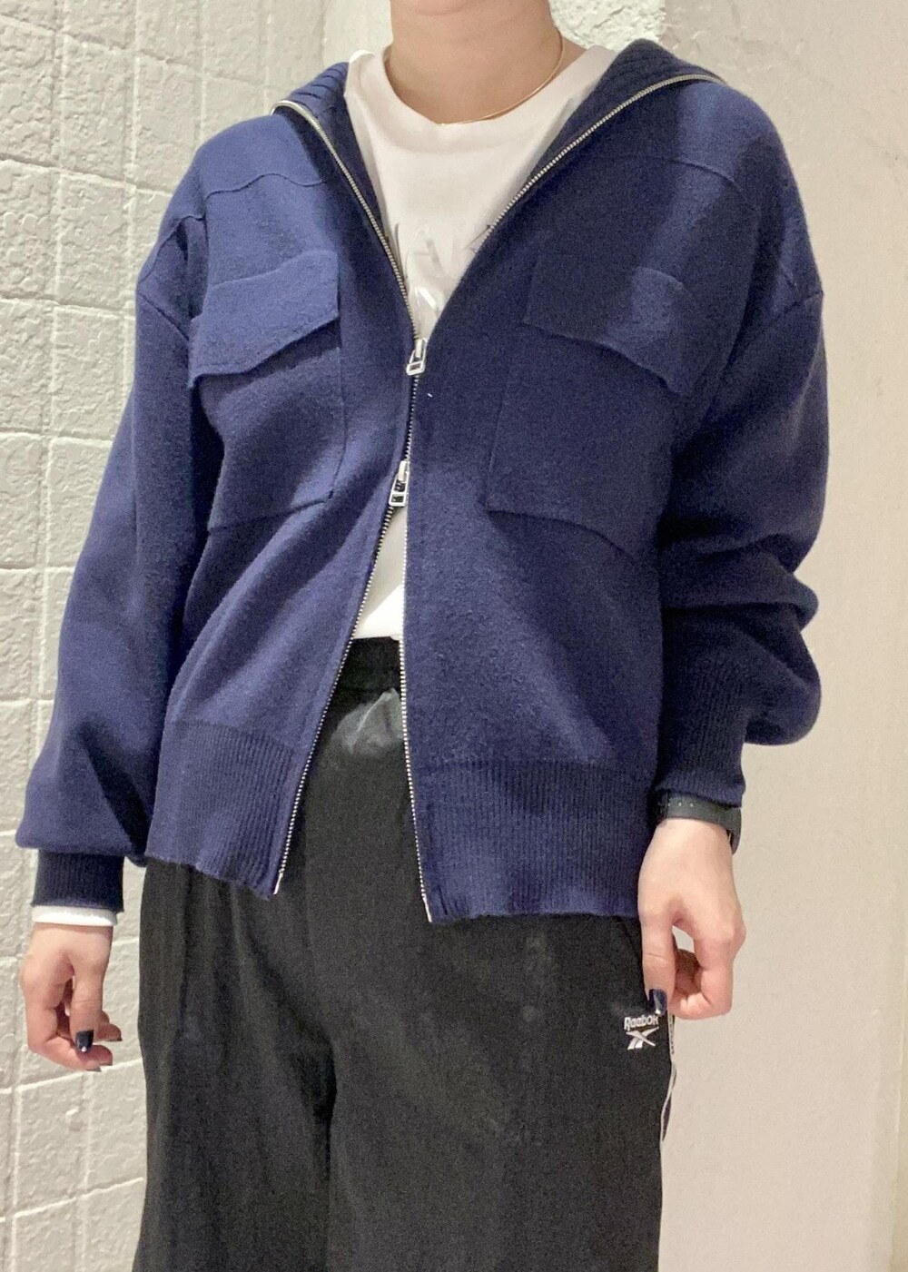 ブラック系のブーツ、ブルー系のカーディガン/ボレロ、ホワイト系のTシャツ/カットソーを着用したレディースの冬コーディネートの5枚目の写真