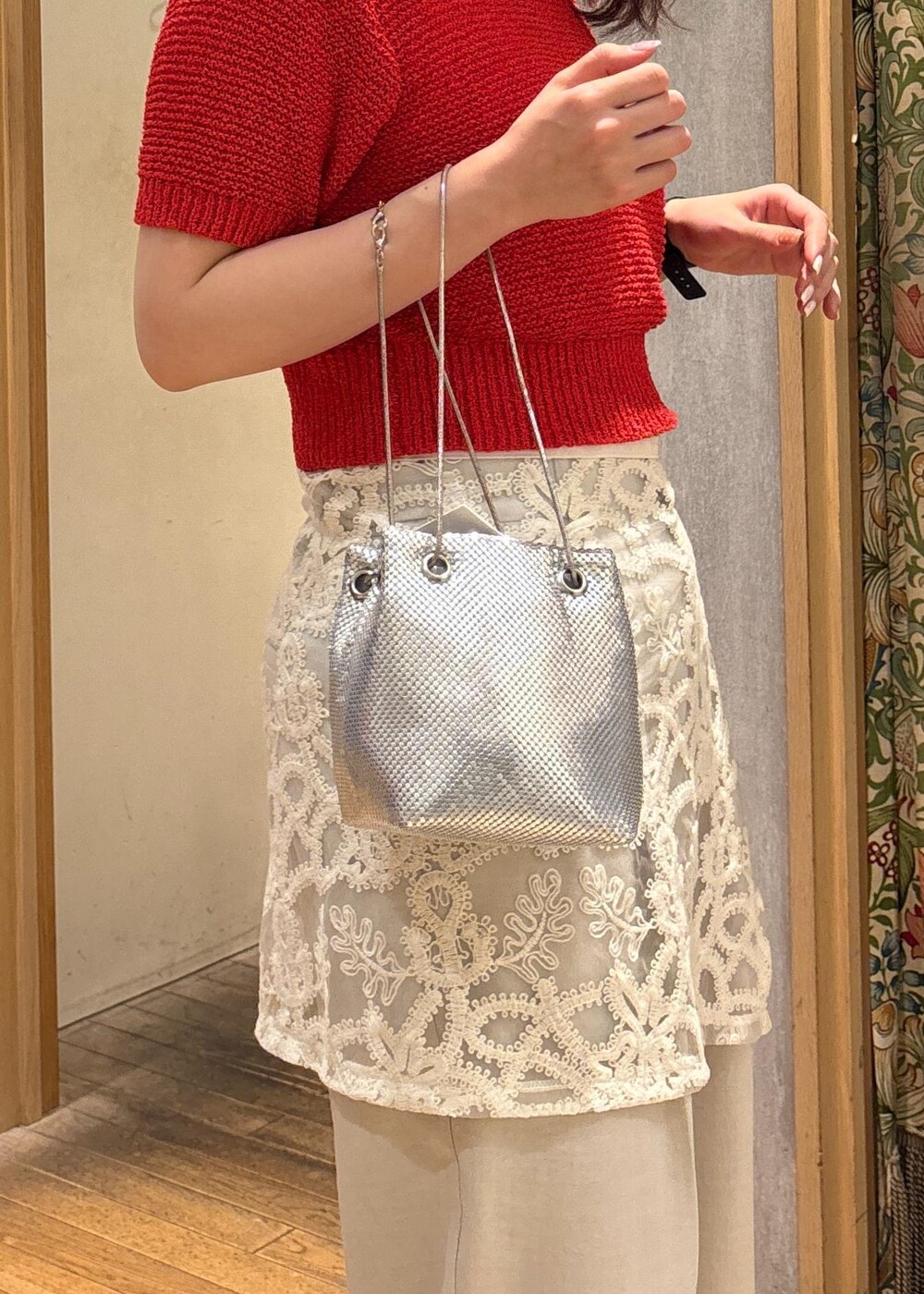 ホワイト系のスラックス、レッド系のニット/セーター、ホワイト系のスカートを着用したレディースの夏コーディネートの5枚目の写真