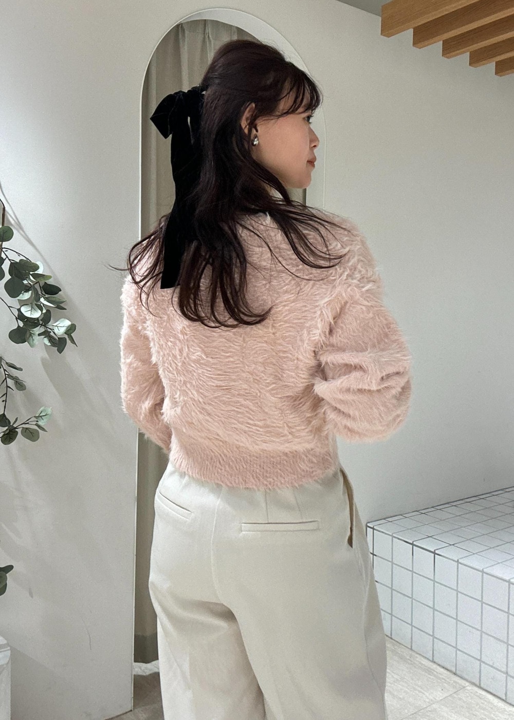 ブラウン系のショルダーバッグ、ブラック系のブーツ、ピンク系のカーディガン/ボレロを着用したレディースの冬コーディネートの6枚目の写真