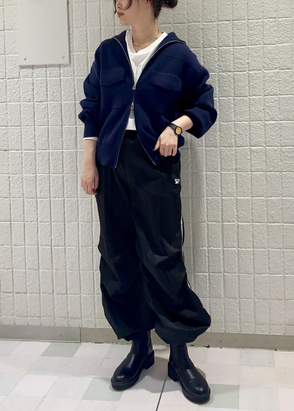 ブラック系のブーツ、ブルー系のカーディガン/ボレロ、ホワイト系のTシャツ/カットソーを着用したレディースの冬コーディネートの2枚目の写真